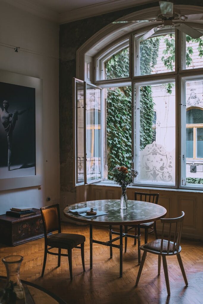 Interior of cozy elegant apartment with big window and classic wooden furniture